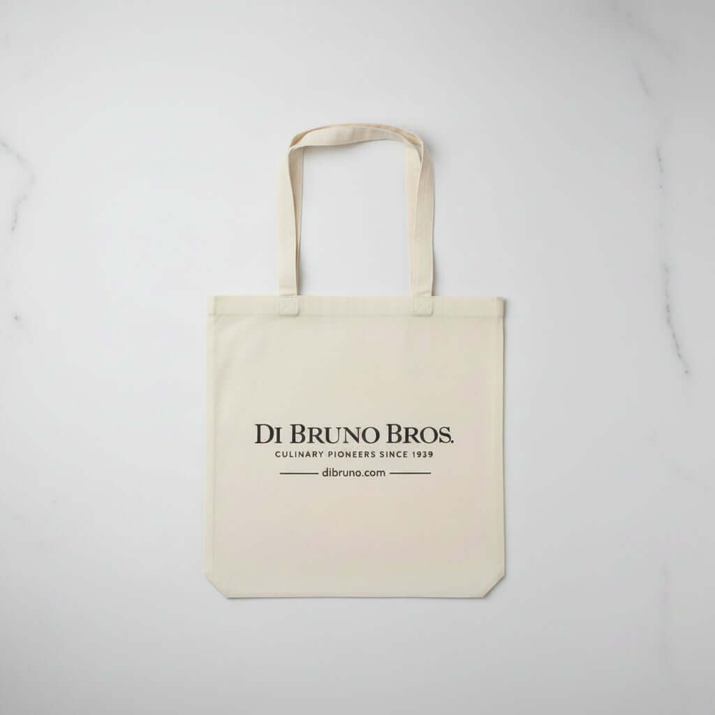 Beige tote bag with 'Di Bruno Bros.' branding on a light gray background