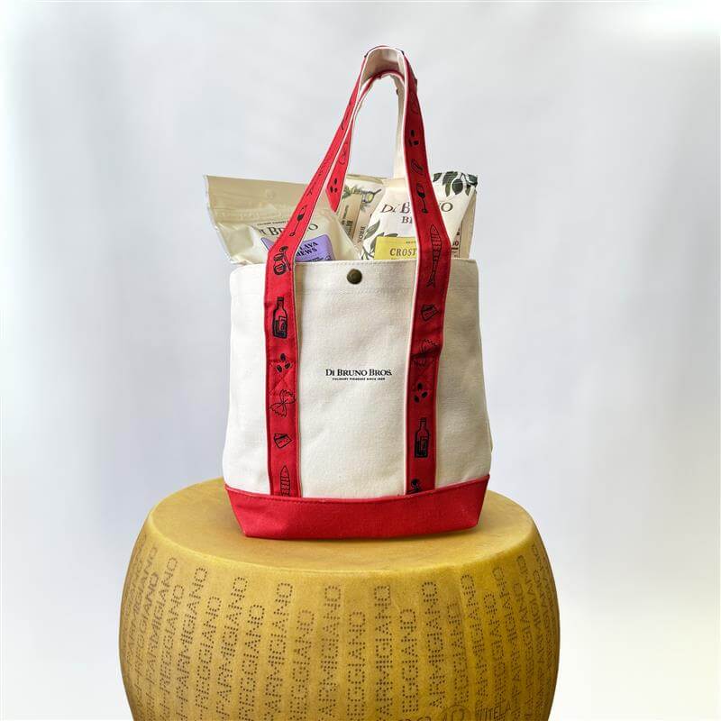 White tote bag with red handles on a wooden block against a white background