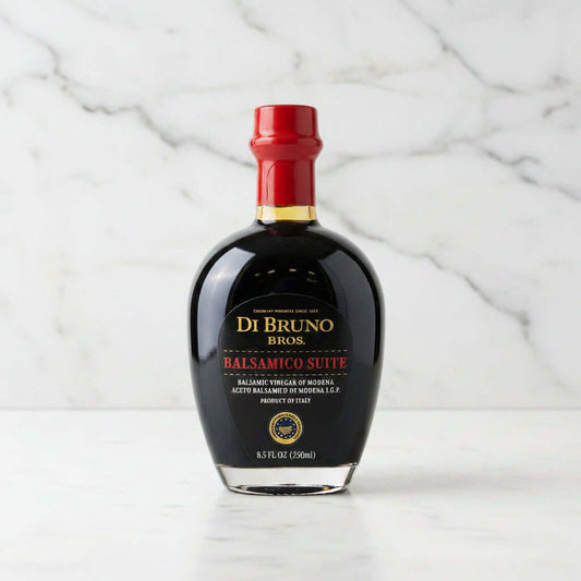 Bottle of Di Bruno Bros Balsamic Vinegar on a gray surface with a metallic background