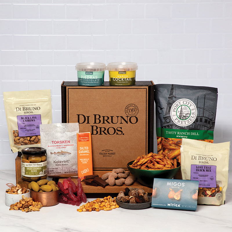 An assortment of tasty gourmet snacks displayed in front of a Di Bruno Bros. gift box.