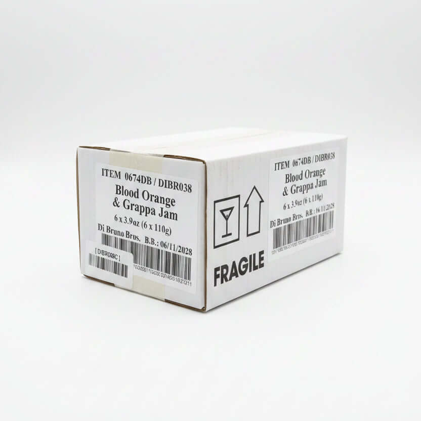 Box of Blood Orange & Grappa Jam with 'Fragile' label on a black surface.