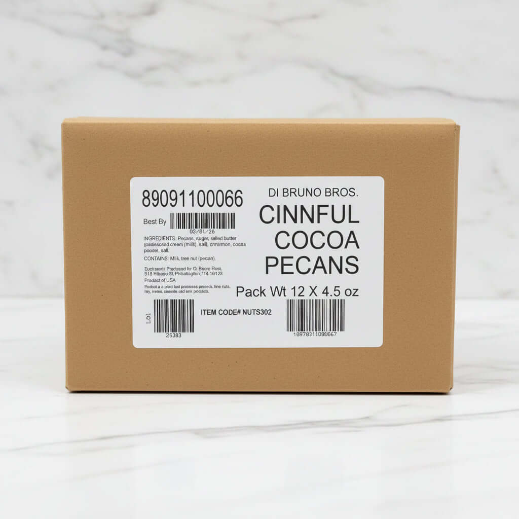 Cardboard box with a label for DI Bruno Bros. Cinnful Cocoa Pecans on a black surface.