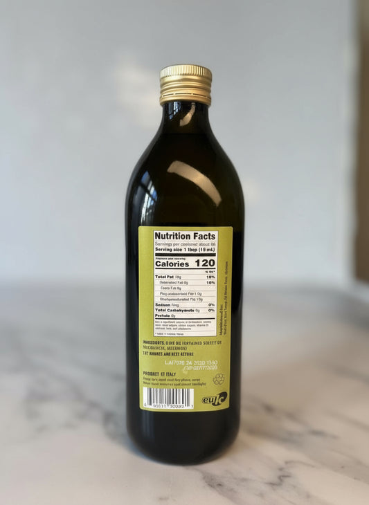 Bottle of olive oil with a nutrition facts label on a marble surface