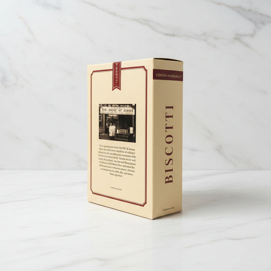 Beige biscotti box with text and a black and white photo on a dark surface.