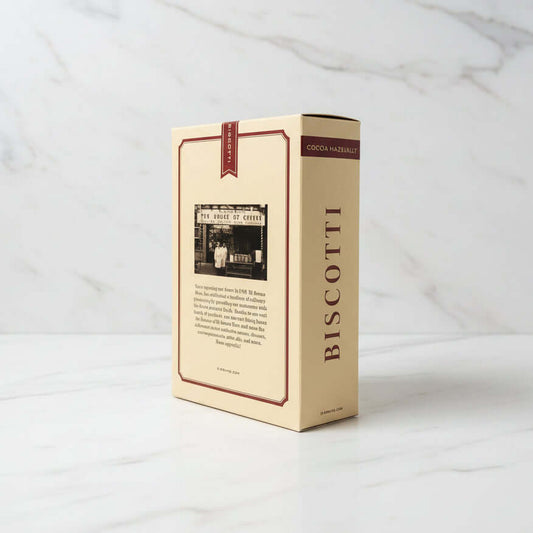 Beige biscotti box with text and a black and white photo on a dark surface.