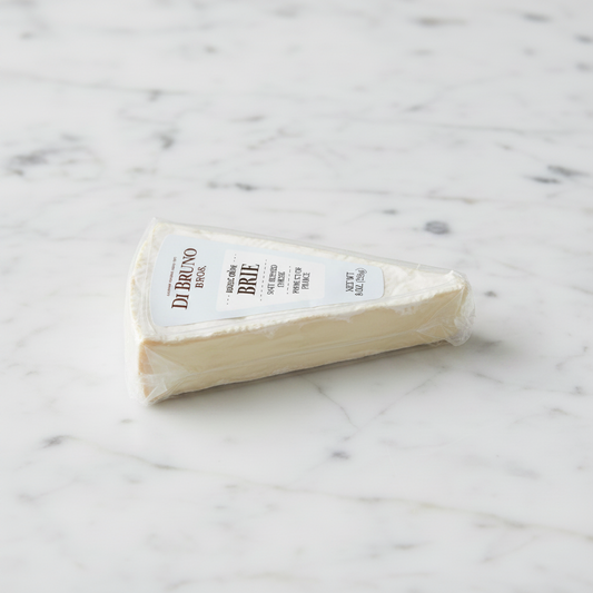 A wedge of Di Bruno Brie cheese on a white background with a small printed number below it.