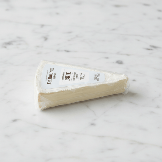 Side view of a wedge of Di Bruno Brie cheese on a white background with a small printed number below it.