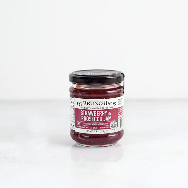 A jar of Strawberry & Prosecco Jam by Di Bruno Bros, with a label showing the product name and a clear jar revealing the red jam inside.