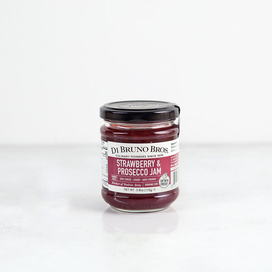 A jar of Strawberry & Prosecco Jam by Di Bruno Bros, with a label showing the product name and a clear jar revealing the red jam inside.