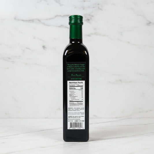 Bottle of olive oil with a nutrition label on a reflective surface