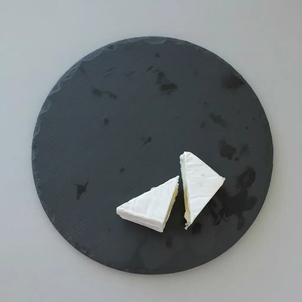 Two triangles of white cheese on a dark slate surface