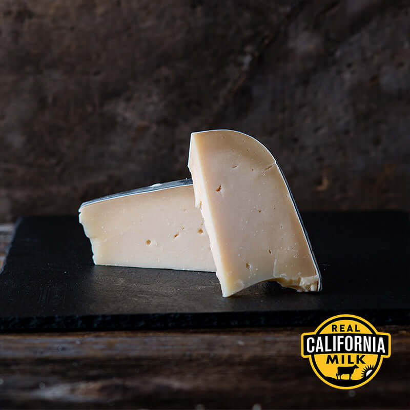 Midnight Moon goat gouda cheese wedge showcasing its smooth texture and unique flavor, made from real California milk.