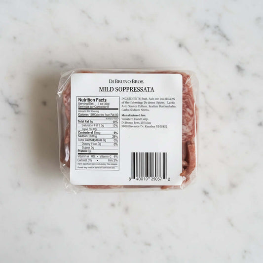 Packaged mild soppressata with a label on a dark background