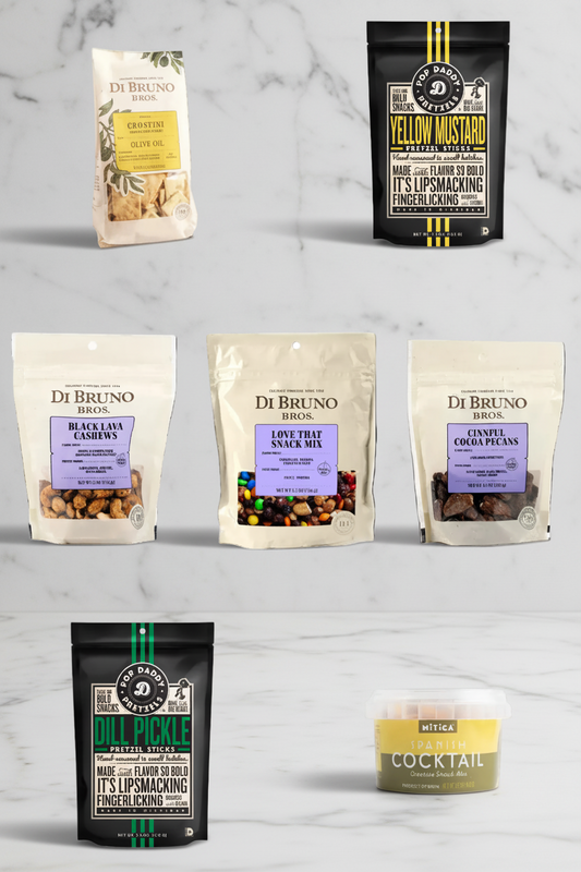 Collection of Di Bruno Bros. snack mixes and a cocktail on a marble surface