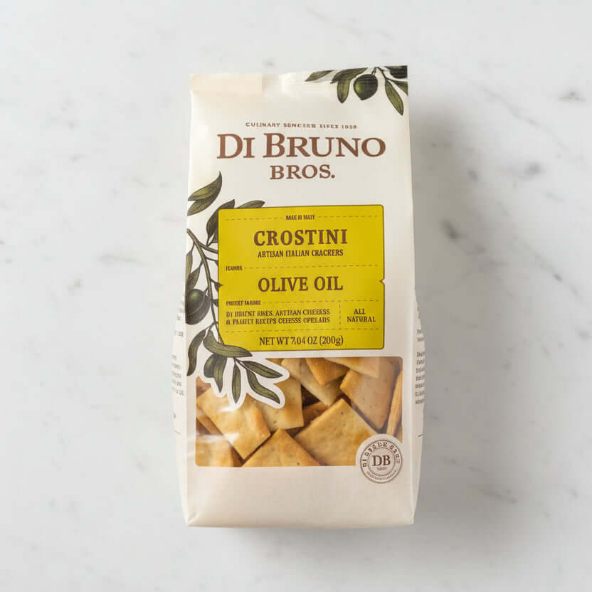 Di Bruno Bros Crostini Olive Oil package on a dark surface with a neutral background