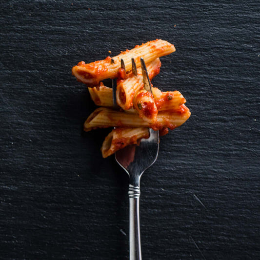 premium arrabbiata pasta sauce on fork with penne pasta