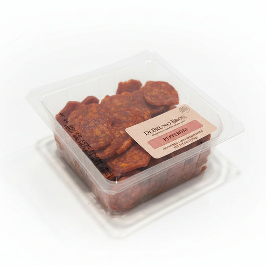 Packaged pepperoni slices with a label on a white surface