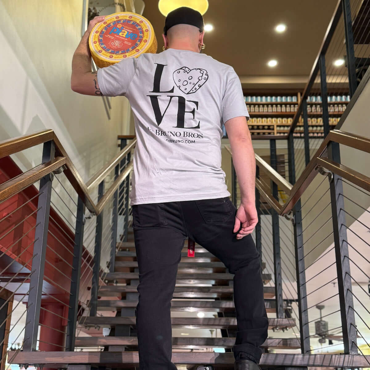 Person holding a cheese wheel at Di Bruno Bros. Alimentari