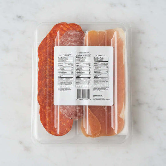 Packaged deli meats including salami and prosciutto on a black surface