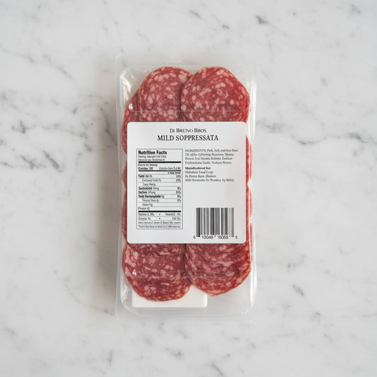 Packaged salami with a label on a dark background