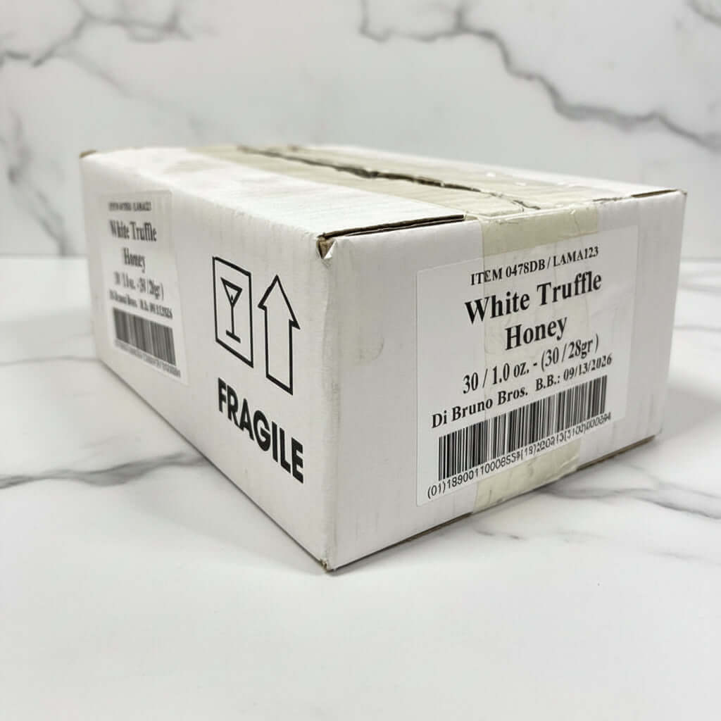 Box of White Truffle Honey with fragile label on a black surface