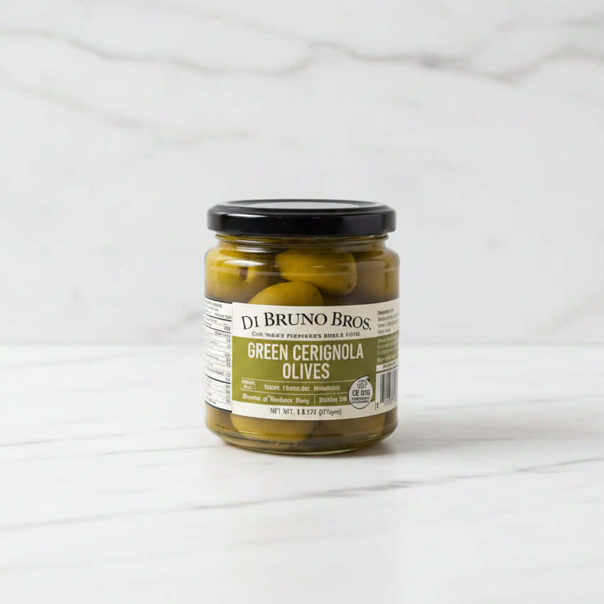 Jar of DeBruno Bros Green Cerignola Olives on a white surface with a blurred background