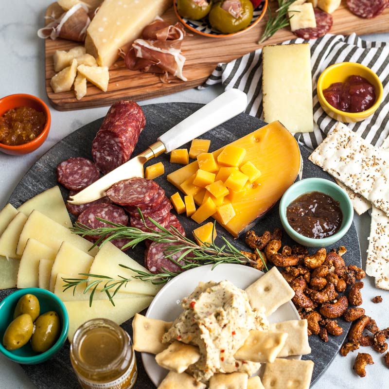 An extravagant assortment of gourmet cheeses, meats, and crackers neatly arranged in a large Di Bruno Bros. wooden gift crate.