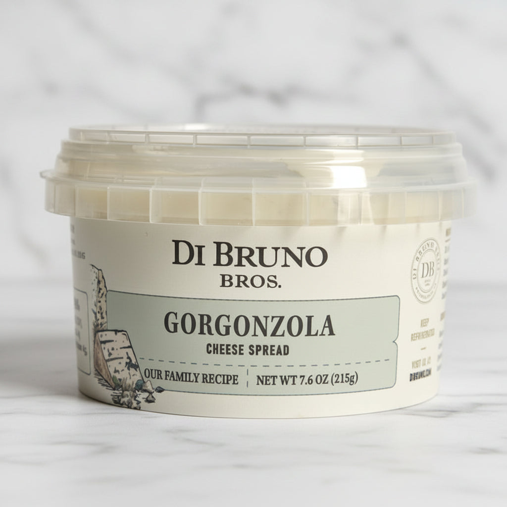 A plastic tub of Di Bruno Bros. Gorgonzola Cheese Spread with a white label featuring the product name and a brief description.