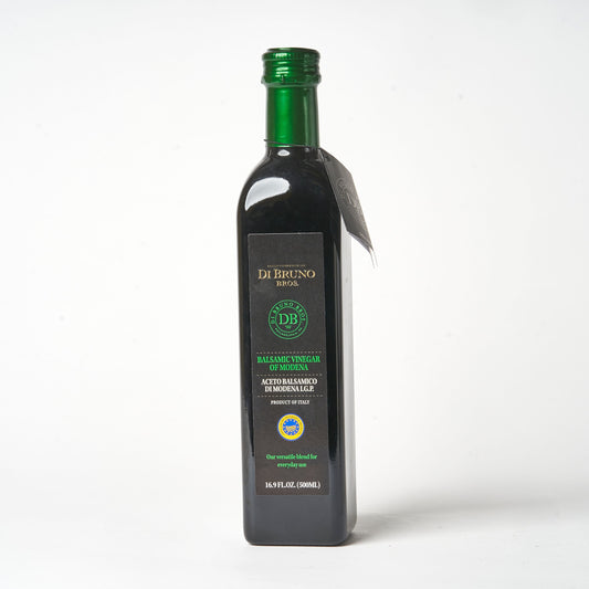 A bottle of Di Bruno Bros. IGP Classico Balsamic Vinegar with a green label and cap, on a white background.