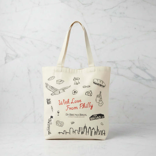 Tote bag with Philadelphia-themed graphics and text on a wooden surface