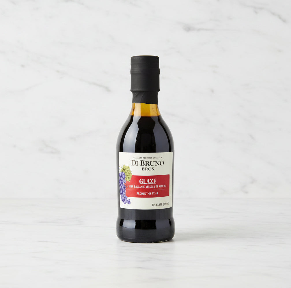 Bottle of Di Bruno Bros glaze on a dark surface with a white background