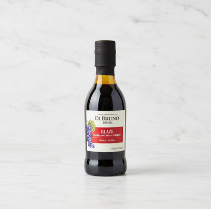 Bottle of Di Bruno Bros glaze on a dark surface with a white background