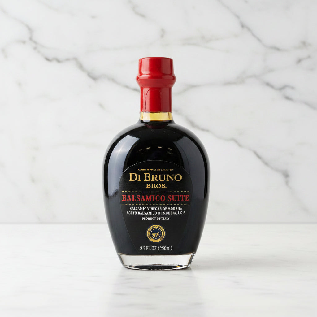 Bottle of Di Bruno Bros Balsamic Vinegar on a gray surface with a metallic background