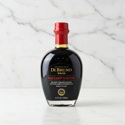 Bottle of Di Bruno Bros Balsamic Vinegar on a gray surface with a metallic background
