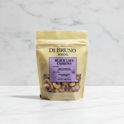 Di Bruno Bros Black Lava Cashews package on a black surface with a white box in the background