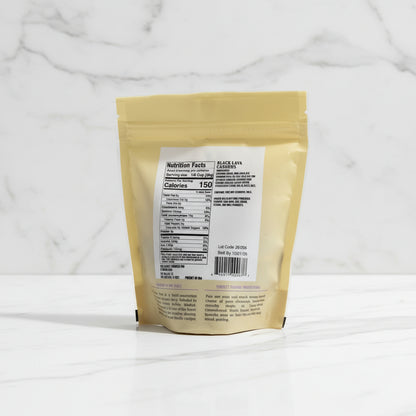 Back of a yellow package with nutritional label on a dark surface