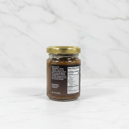 Small glass jar with a gold lid on a black surface