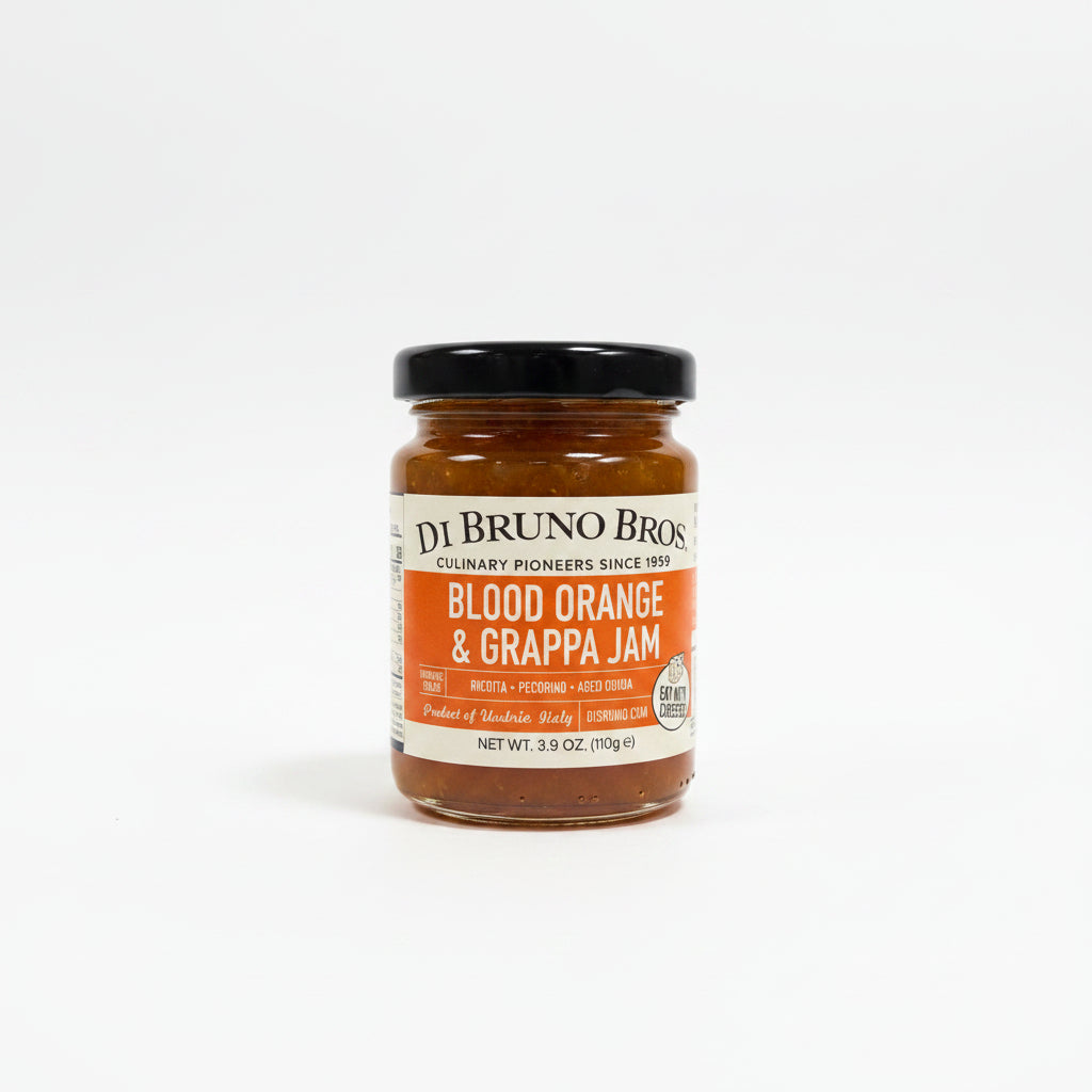 Jar of Di Bruno Bros Blood Orange & Grappa Jam on a dark surface with a white background