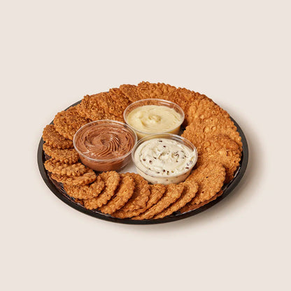 Round tray of cannoli crisps and three small cups of creams.