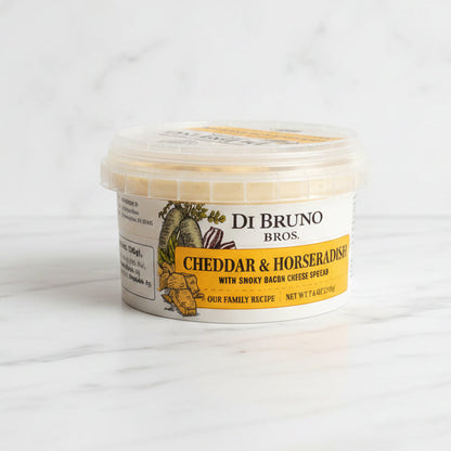 Container of De Bruno Bros Cheddar & Horseradish on a dark surface with a white background
