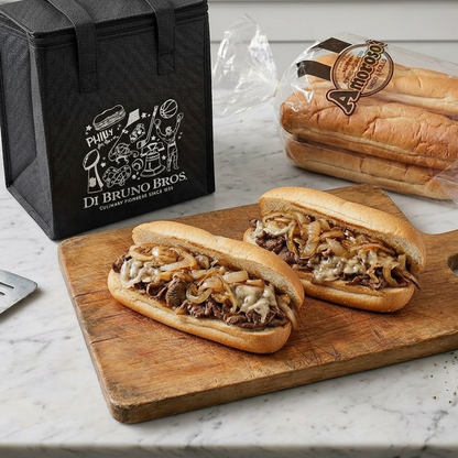 Two sandwiches on a wooden cutting board with a black box labeled 'Di Bruno Bros' in the background.