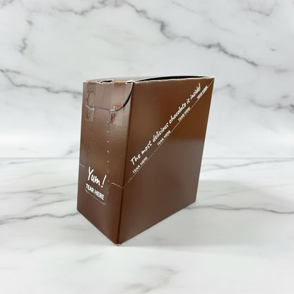 Brown chocolate packaging with white text on a dark surface