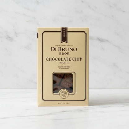 Box of Di Bruno Bros. Chocolate Chip Biscotti on a dark surface with a white box in the background.