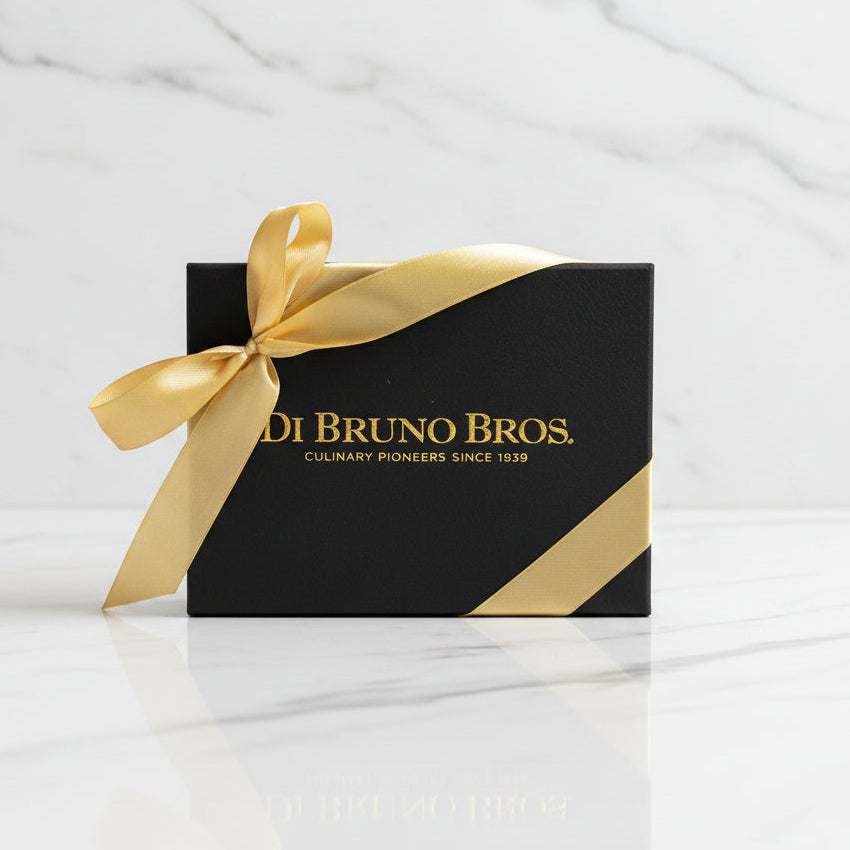 Black box with gold ribbon and 'Di Bruno Bros.' branding on a gray surface.