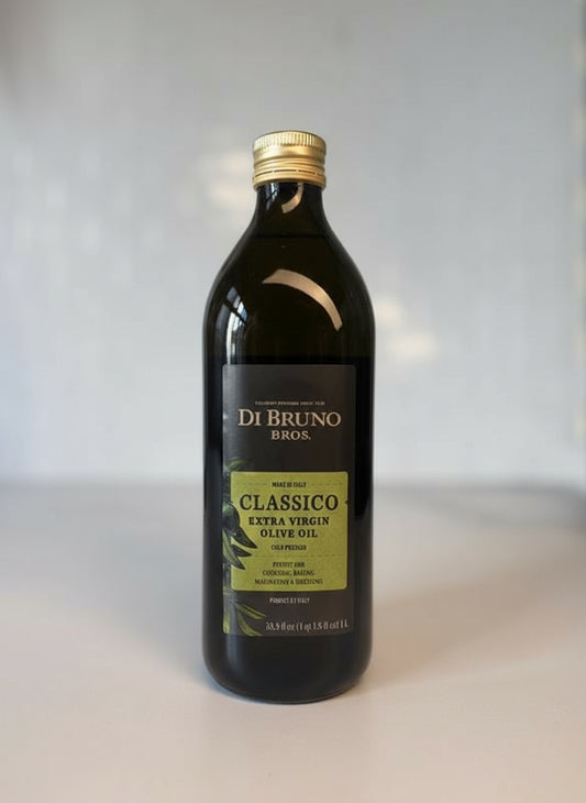 Bottle of Di Bruno Bros Classico Extra Virgin Olive Oil on a marble surface with a white background