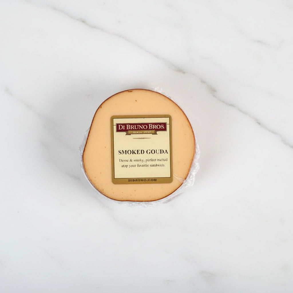 A round piece of smoked gouda cheese with a label in the center displaying the cheese name and brand.