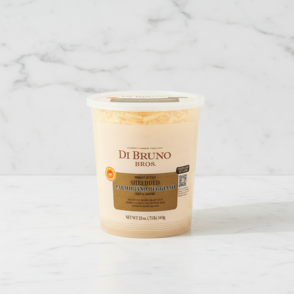 A 12 oz plastic tub of Di Bruno Bros. Shredded Parmigiano Reggiano aged 24 months, featuring a beige label with a brown central panel and a white lid, set against a plain white background.