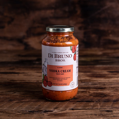 A jar of Di Bruno Bros. Vodka Cream Tomato Sauce on a wooden surface.