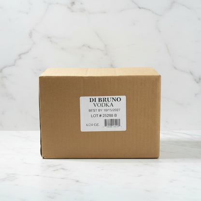 Cardboard box of Di Bruno Vodka on a black surface with warehouse background
