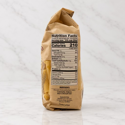 A bag of pasta standing upright against a plain white background, showing the back of the packaging with the nutrition facts label visible.